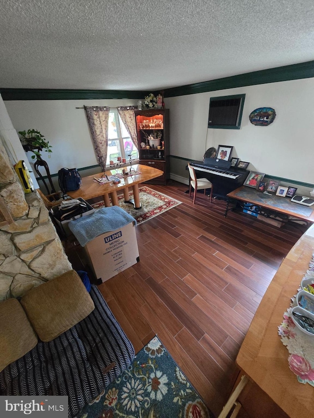 living room featuring a textured ceiling, hardwood / wood-style flooring, and crown molding