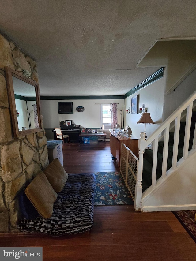 foyer featuring a textured ceiling, dark wood-type flooring, and crown molding