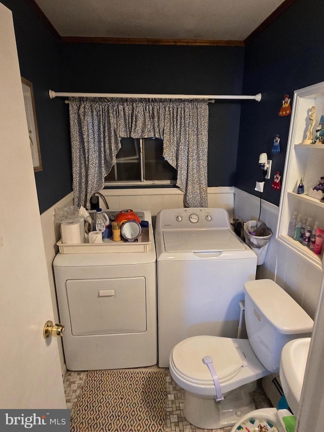 bathroom featuring toilet and washing machine and clothes dryer