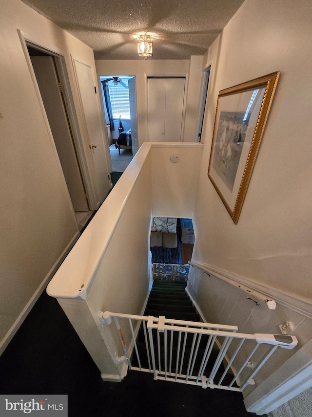 stairway featuring a textured ceiling