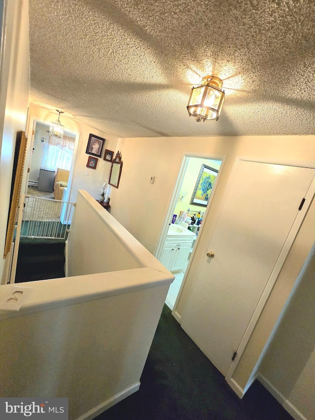 stairs featuring a textured ceiling