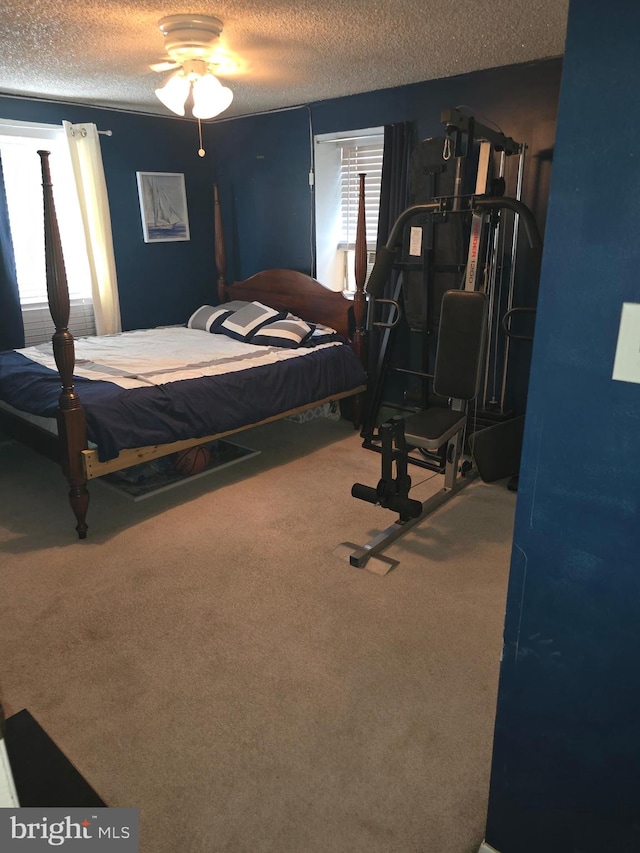 bedroom with a textured ceiling, ceiling fan, and carpet floors