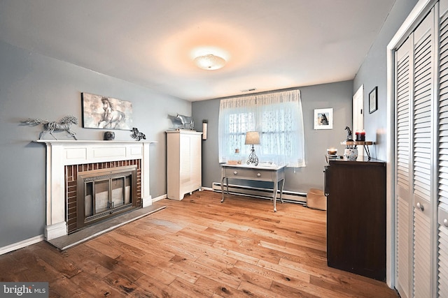 interior space with light hardwood / wood-style floors, a baseboard radiator, and a fireplace