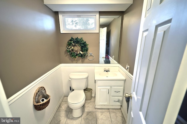 bathroom with toilet, vanity, and tile patterned flooring