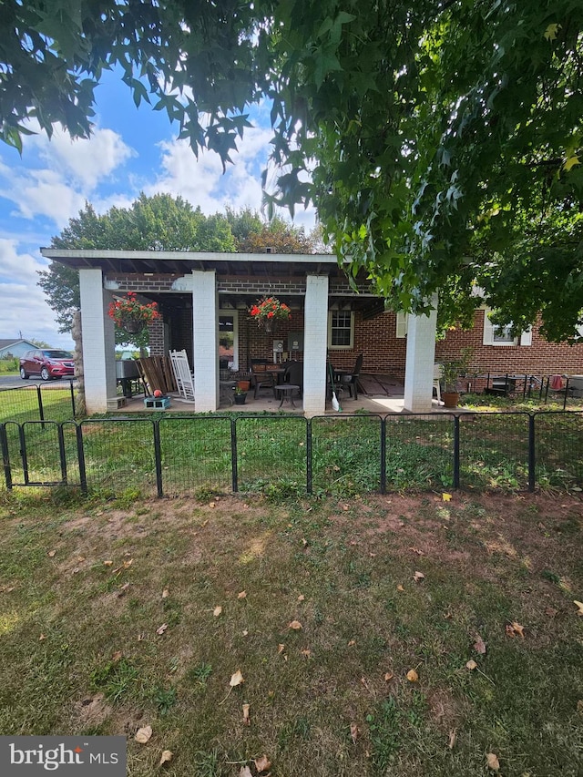 rear view of property with a patio and a lawn