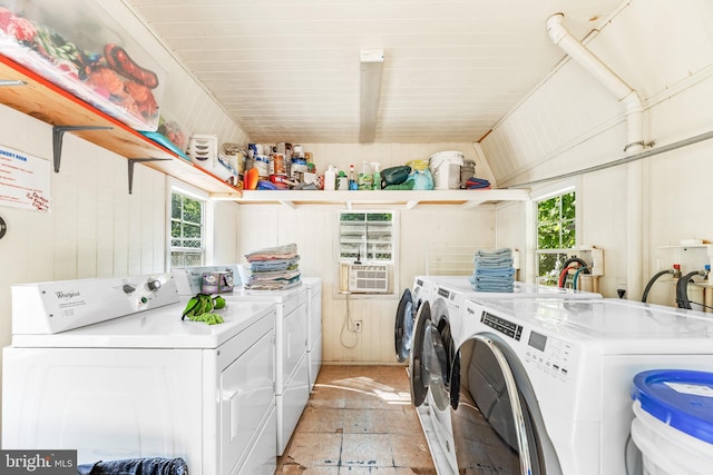 laundry room with washing machine and dryer and wooden walls