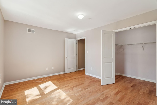 unfurnished bedroom featuring a closet and hardwood / wood-style flooring