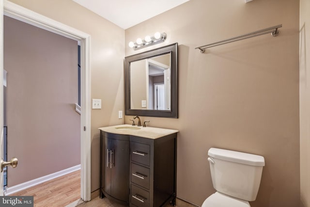 bathroom featuring wood-type flooring, vanity, and toilet