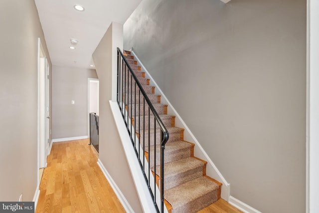 staircase with hardwood / wood-style floors