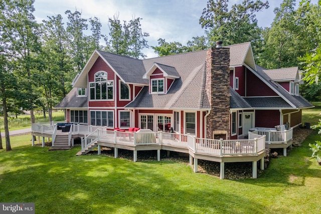 rear view of house featuring a wooden deck and a yard