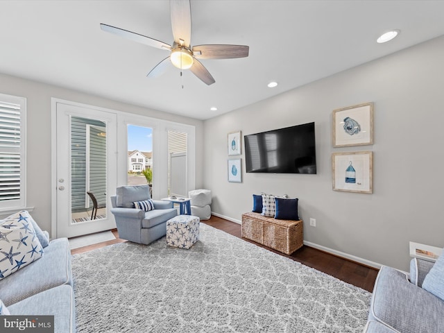 living room featuring dark wood-type flooring and ceiling fan