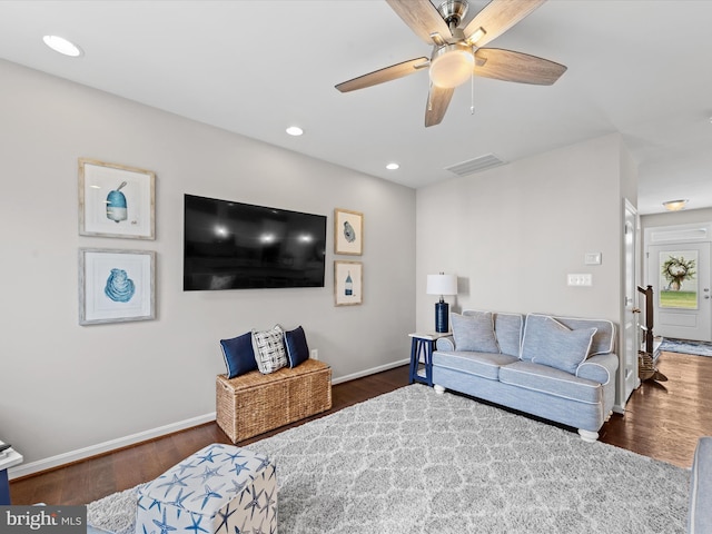 living room with dark hardwood / wood-style flooring and ceiling fan