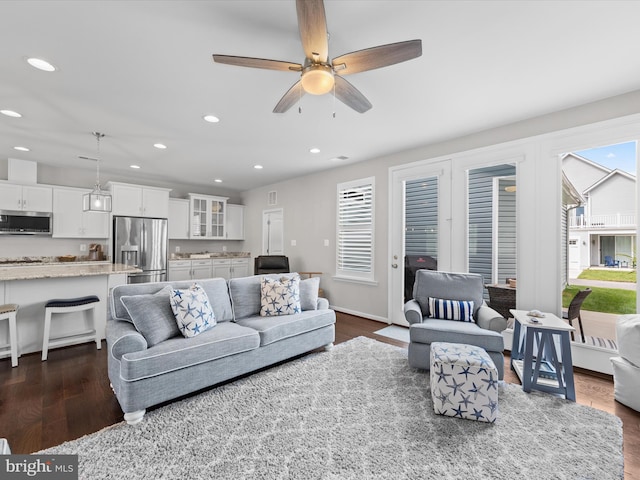 living room with ceiling fan and dark wood-type flooring