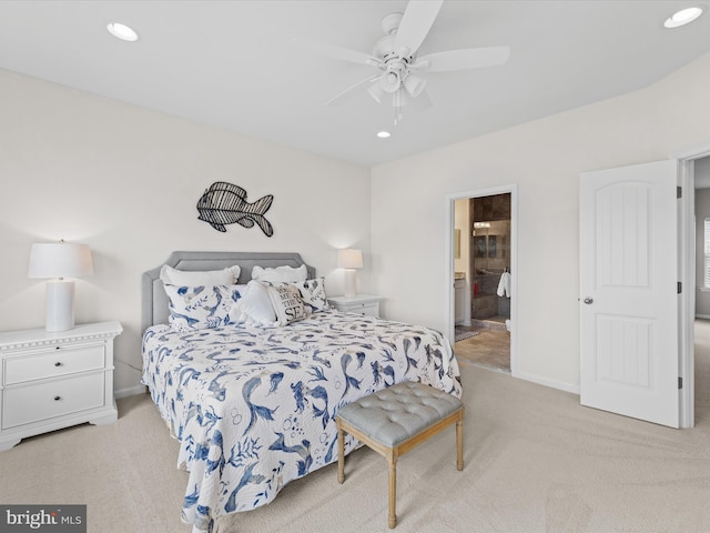 bedroom featuring light carpet, ensuite bath, and ceiling fan