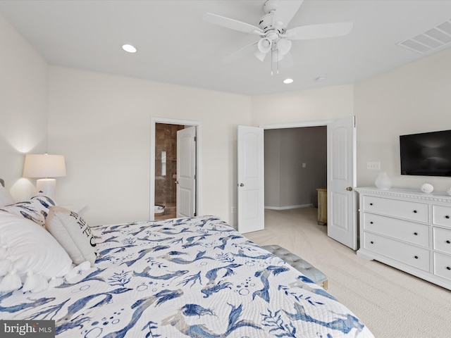 bedroom featuring light carpet, ensuite bath, and ceiling fan