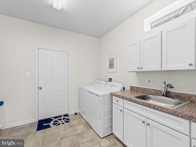 laundry area with cabinets, washing machine and dryer, and sink