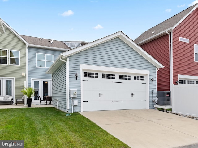 back of property featuring a lawn, a garage, and central air condition unit