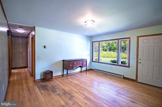 foyer entrance featuring baseboard heating and wood-type flooring