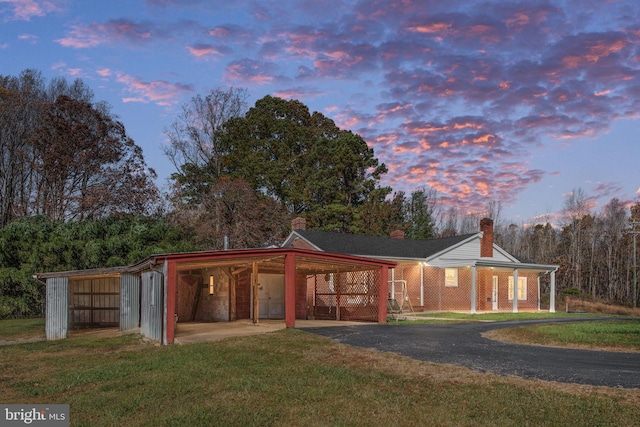 view of front of home featuring an outbuilding and a lawn