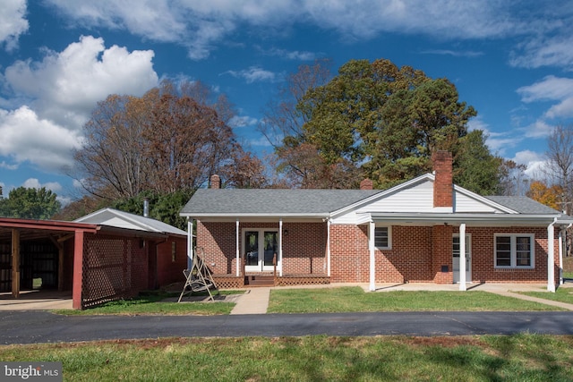 view of front of house with a front yard, covered porch, and a carport