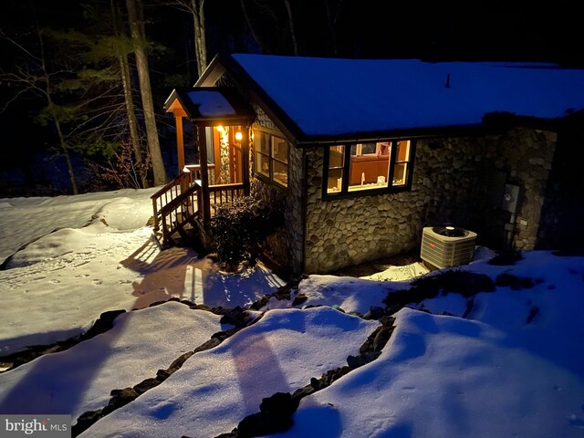 view of snowy exterior featuring central AC unit