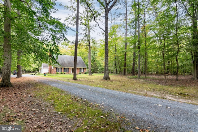 exterior space with gravel driveway and brick siding