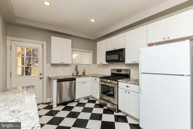 kitchen with decorative backsplash, sink, stainless steel appliances, and white cabinets