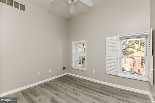 empty room with ceiling fan and hardwood / wood-style flooring