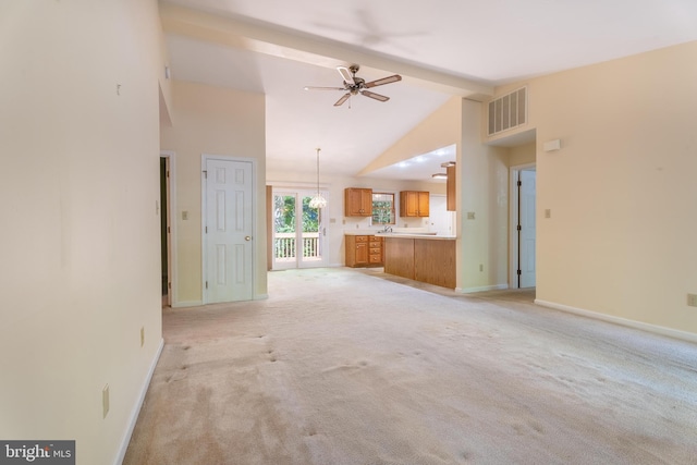 unfurnished living room featuring high vaulted ceiling, ceiling fan, beamed ceiling, and light carpet