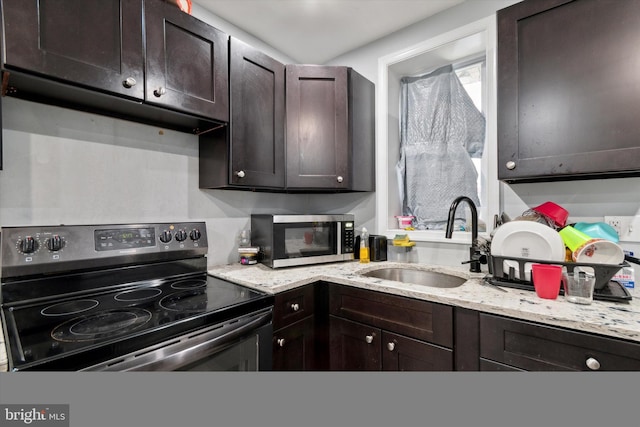 kitchen featuring dark brown cabinetry, sink, electric range, and light stone countertops