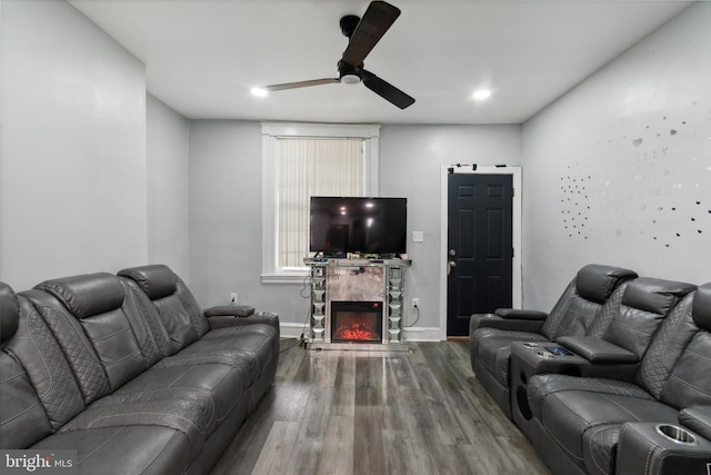 living room with wood-type flooring, a fireplace, and ceiling fan