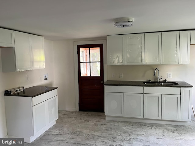 kitchen featuring white cabinets and sink