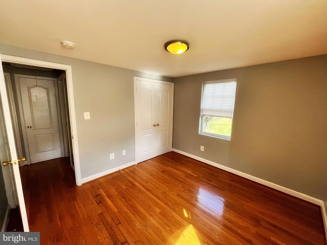 unfurnished bedroom featuring a closet and wood-type flooring