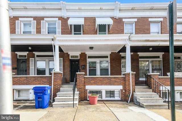 919 N Lakewood Ave, Baltimore, MD 21205 - townhome / multi-family property with a porch and brick siding