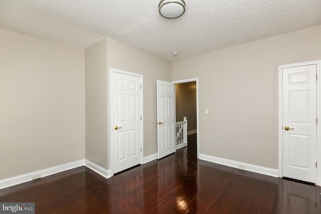 919 N Lakewood Ave, Baltimore, MD 21205 - unfurnished bedroom with a textured ceiling, baseboards, and wood finished floors