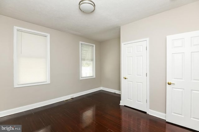 919 N Lakewood Ave, Baltimore, MD 21205 - unfurnished bedroom with baseboards and dark wood-style flooring