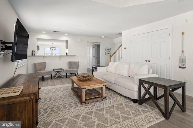 living room featuring wood-type flooring and a chandelier