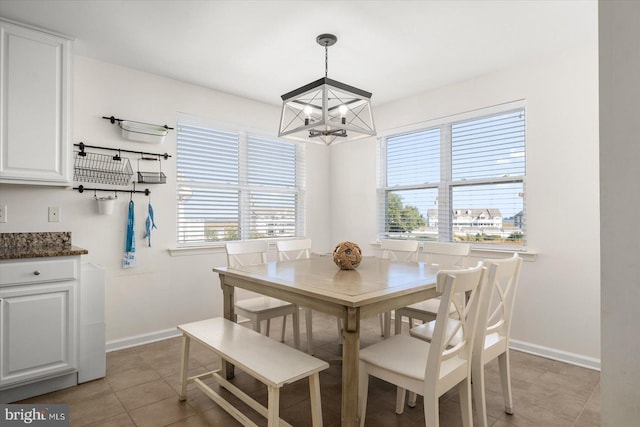 dining space featuring light tile patterned flooring and an inviting chandelier