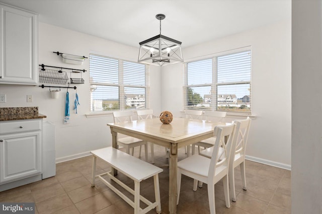 tiled dining area featuring plenty of natural light and a chandelier