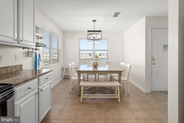 tiled dining room featuring a notable chandelier