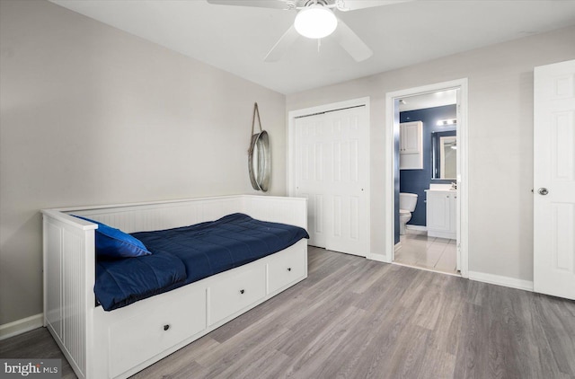 bedroom featuring ensuite bathroom, ceiling fan, a closet, and light hardwood / wood-style flooring