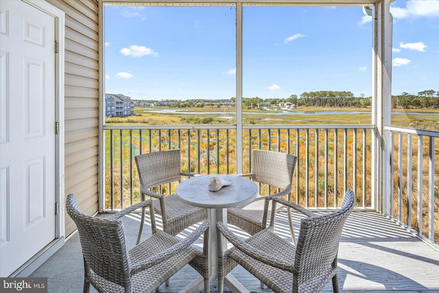 sunroom / solarium featuring a water view and a wealth of natural light