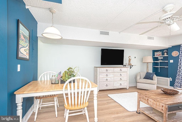 dining area featuring a textured ceiling, ceiling fan, and hardwood / wood-style flooring