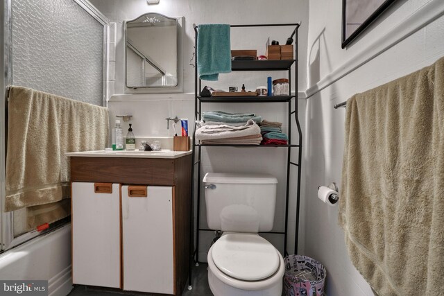 full bathroom with shower / bath combination with glass door, vanity, and toilet