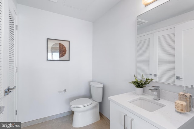 bathroom featuring tile patterned flooring, vanity, and toilet