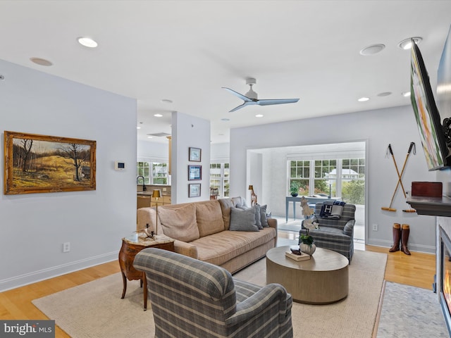 living room with light hardwood / wood-style floors and ceiling fan