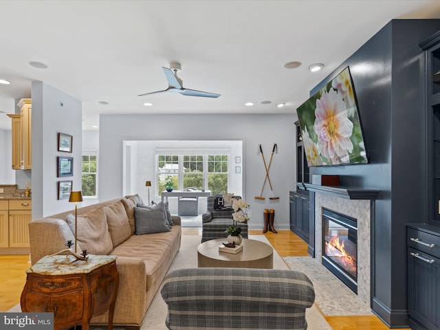 living room with light wood-type flooring and ceiling fan