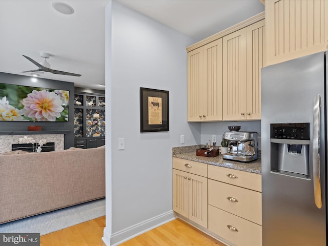 kitchen with ceiling fan, cream cabinets, light wood-type flooring, and stainless steel fridge