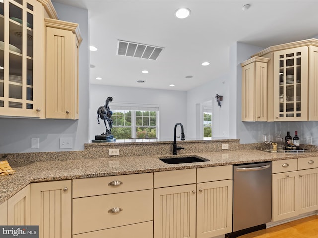 kitchen featuring light hardwood / wood-style floors, light stone countertops, sink, and stainless steel dishwasher