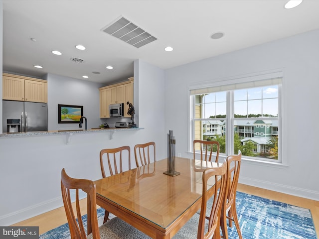 dining space featuring light hardwood / wood-style floors and sink